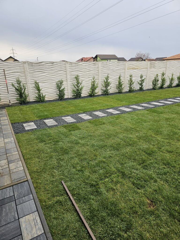 Bordură decorativă din criblură neagră de-a lungul gardului cu gazon rulou verde - finalizare amenajare Giroc